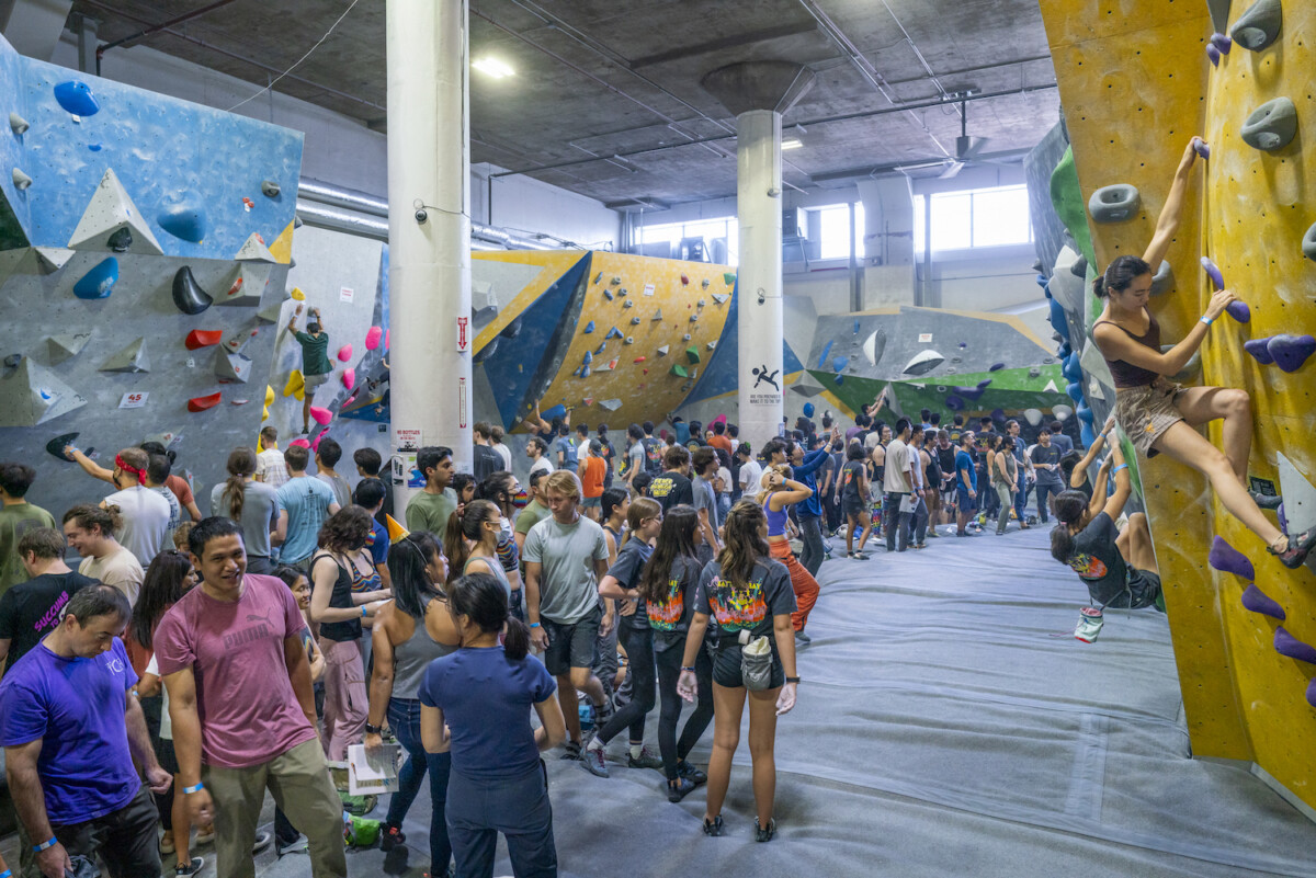 Event attendees climbing and watching in the gym