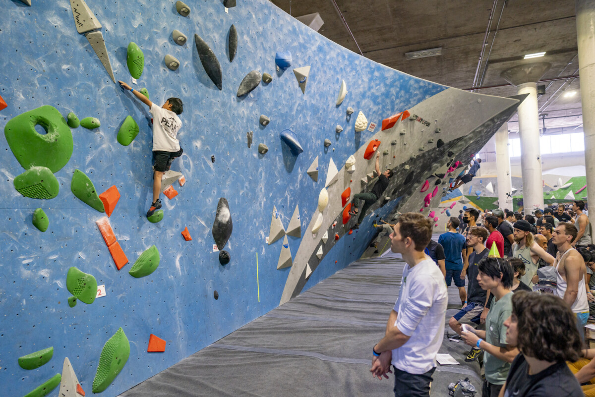 Contestants climbing and spectating in the gym