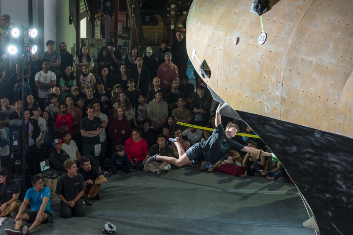 A climber swinging wide on a big move on the wall